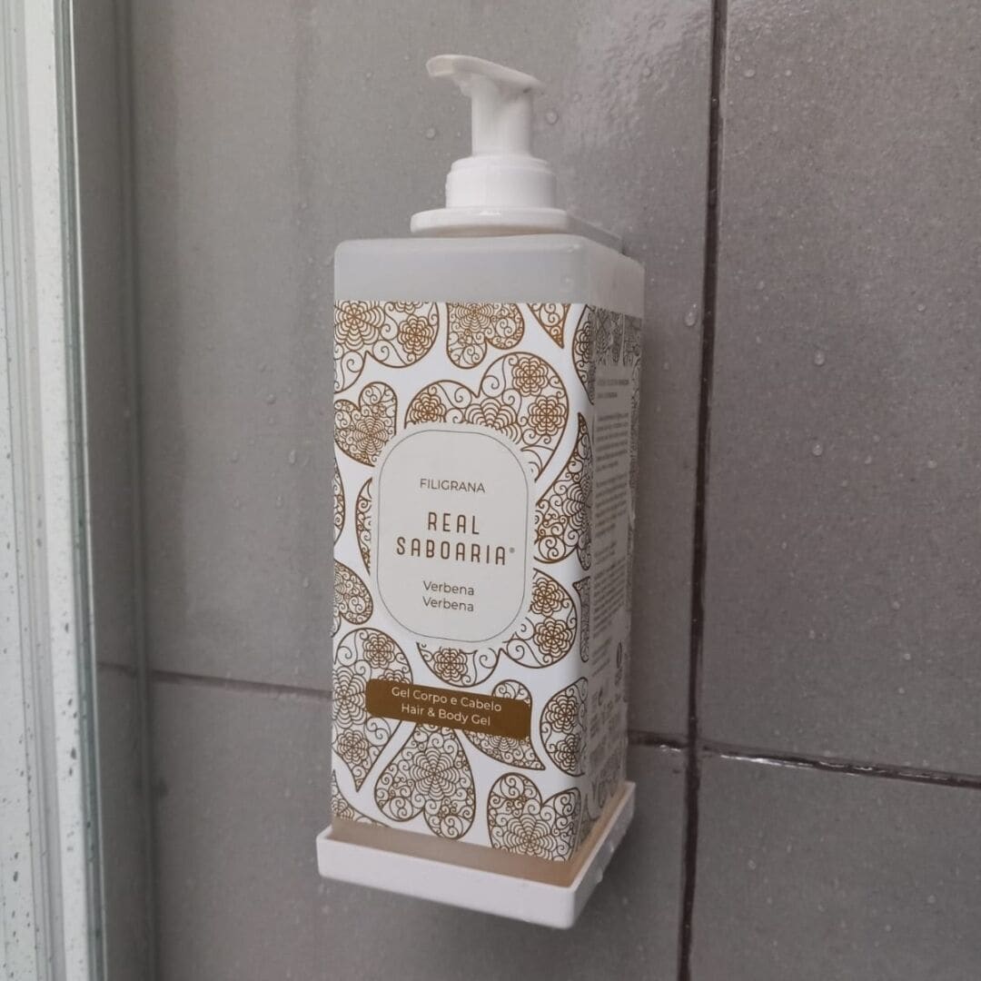 A bottle of Filigrana Real Saboaria hair and body gel on a white shelf against a tiled wall.