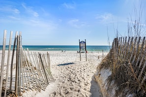Walk along the beach to the ocean, where a signpost marks the way to the shore.