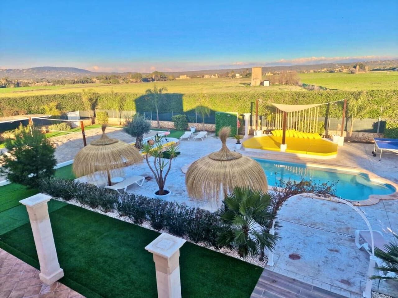 Un espace piscine offrant une vue dégagée sur le paysage environnant, notamment sur un vignoble en arrière-plan.