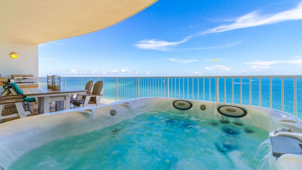 A hot tub with a view of the ocean, a table with chairs, and a railing. - Lazy River! D tower 1308D sleeps10 gulf front. (Orange Beach)
