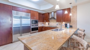 A modern kitchen with granite countertops, stainless steel appliances, and wooden cabinets. - Lazy River! D tower 1308D sleeps10 gulf front. (Orange Beach)