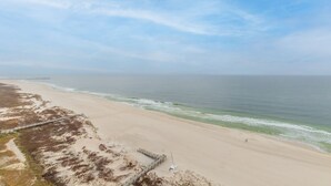 A beach with a wooden walkway leading to a pier. - Lazy River! D tower 1308D sleeps10 gulf front. (Orange Beach)