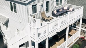 Une maison à deux étages dotée d’un balcon, d’un porche couvert et d’un petit jardin.
