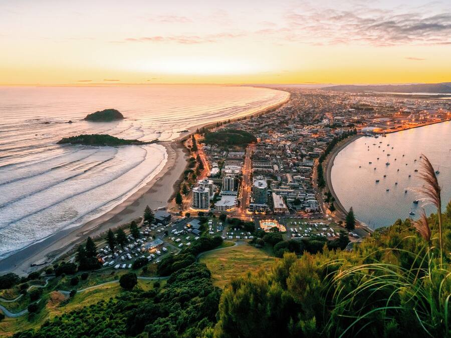 A coastal cityscape with a beach, marina, and residential areas.