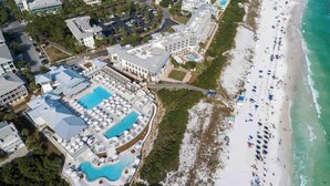 An aerial view of a resort with multiple swimming pools, a beach, and a road leading to the beach. - Watercolor House: Beach Access, & Family Fun! (Santa Rosa Beach)