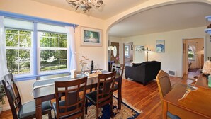 A dining area with a chandelier, wooden chairs, a table, and a view of the outdoors. - Charming 4BR Home in a Great Downtown Location (Mount Shasta)