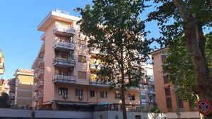 Un immeuble résidentiel à plusieurs étages, doté de balcons, de climatiseurs et d’un panneau indiquant qu’il est interdit de se garer.