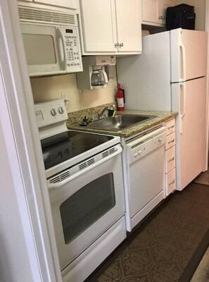Enjoy cooking in this well-equipped kitchen with a microwave, stove, oven, sink, and refrigerator.