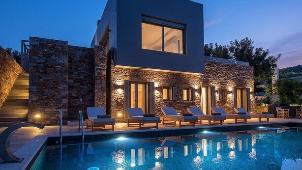 Ein modernes Gebäude mit Pool und Liegestühlen.