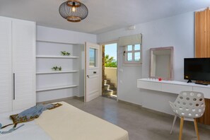 Quarto com cama, escrivaninha, cadeira, televisão e guarda-roupa.