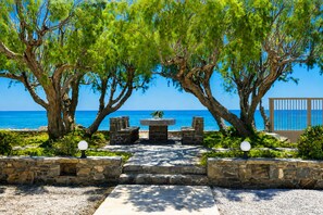 A stone pathway leading to a seating area with a view of the sea. - Seafront 3 bedroom villa (Ierapetra)