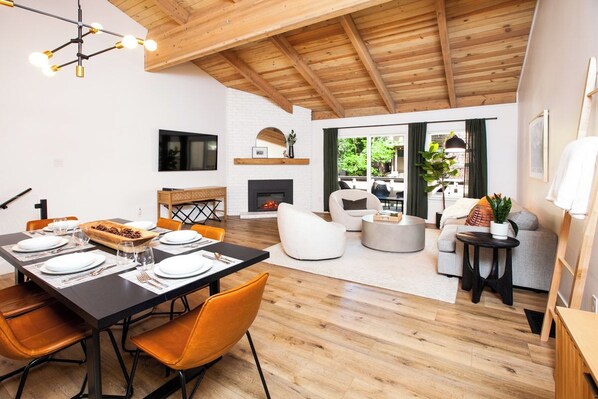 A modern living space with a dining area, fireplace, and seating arrangement.