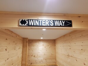 A wooden cabin interior with a sign reading "WINTER'S WAY" pointing to the right. - Gorgeous dog-friendly cabin with great view, deck, hot tub, & gas fireplace (Carrabassett Valley)