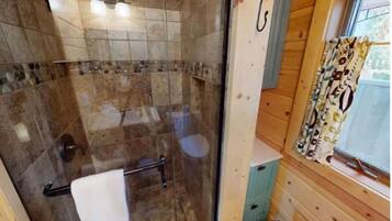 A bathroom with a shower, a toilet, and a sink.