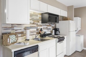 Appartamento, letti multipli, patio, vista giardino | Cucina privata | Frigorifero, microonde, forno, piano cottura