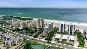 Une zone hôtelière située sur la côte, avec de nombreux immeubles de grande hauteur, une plage et une route.