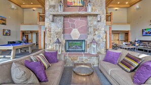 A spacious living area with a stone fireplace, comfortable seating, and a pool table. - Fabulous Grand Timber Lodge Ski In and Ski Out Resort in Breckenridge (Breckenridge)