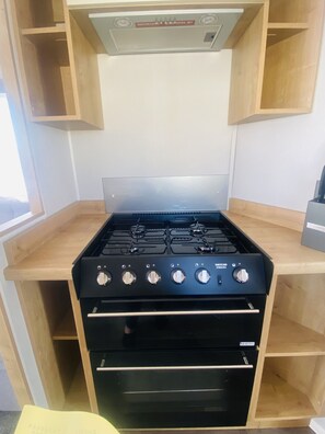 Compact kitchen with a gas stove, oven, and ample storage.