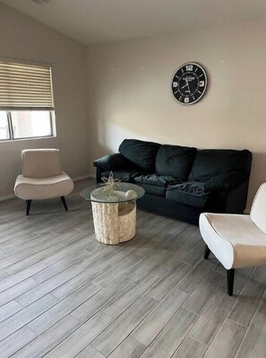 Relax in this inviting living space, featuring a comfortable sofa, armchair, and stylish coffee table.