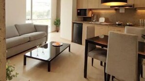 A modern living room with a sofa, coffee table, and dining area. - Beautiful Penthouse in the best area of the LP city (Zona Calacoto La Paz)