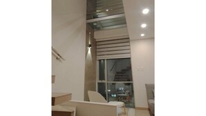 Un intérieur moderne avec un escalier, un coin salon et une grande fenêtre.