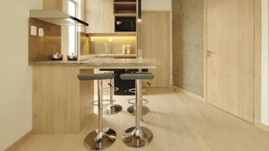 Une cuisine moderne dotée d’un îlot central, de tabourets de bar et d’un four à micro-ondes.