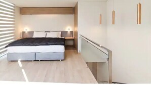 A modern bedroom with a bed, bedside tables, and a wardrobe. - Beautiful Penthouse Duplex @ the best area in La Paz (Zona Calacoto La Paz)