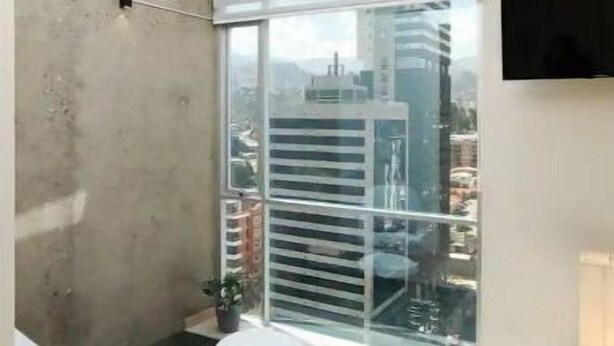 A modern room with a skylight, a glass table, and a chair. - Beautiful Penthouse Duplex @ the best area in La Paz (Zona Calacoto La Paz)