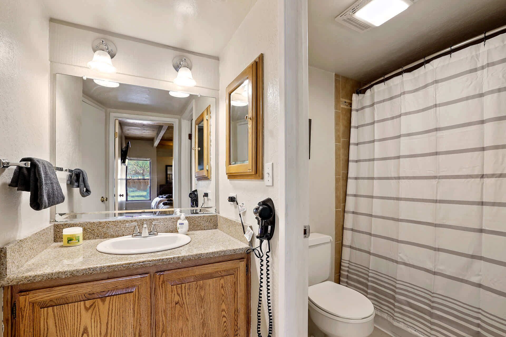 A bathroom with a sink, mirror, and toilet.