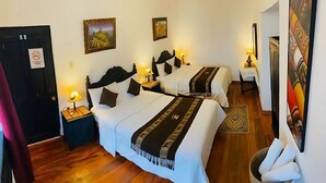 A hotel room with two beds, wooden flooring, and a nightstand with a lamp. - Golden House Hotel  (Cusco)