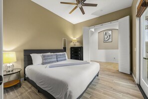 A bedroom with a bed, bedside table, lamp, dresser, and a ceiling fan. - Casa De Amore: Pool, Spa, Casitas, Built-n BBQ! (Indio)