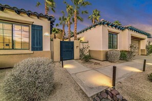 A two-story building with a beige facade, blue shutters, and a tiled roof. - Casa De Amore: Pool, Spa, Casitas, Built-n BBQ! (Indio)