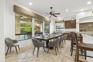 A spacious kitchen with a large island, modern appliances, and large windows offering views of the outdoors. - Casa De Amore: Pool, Spa, Casitas, Built-n BBQ! (Indio)