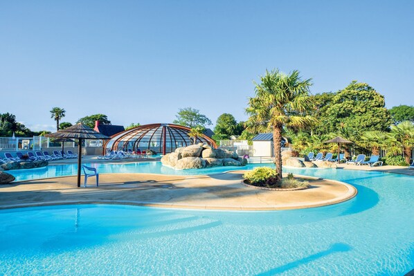 Swimming pool with palm trees and lounge chairs.