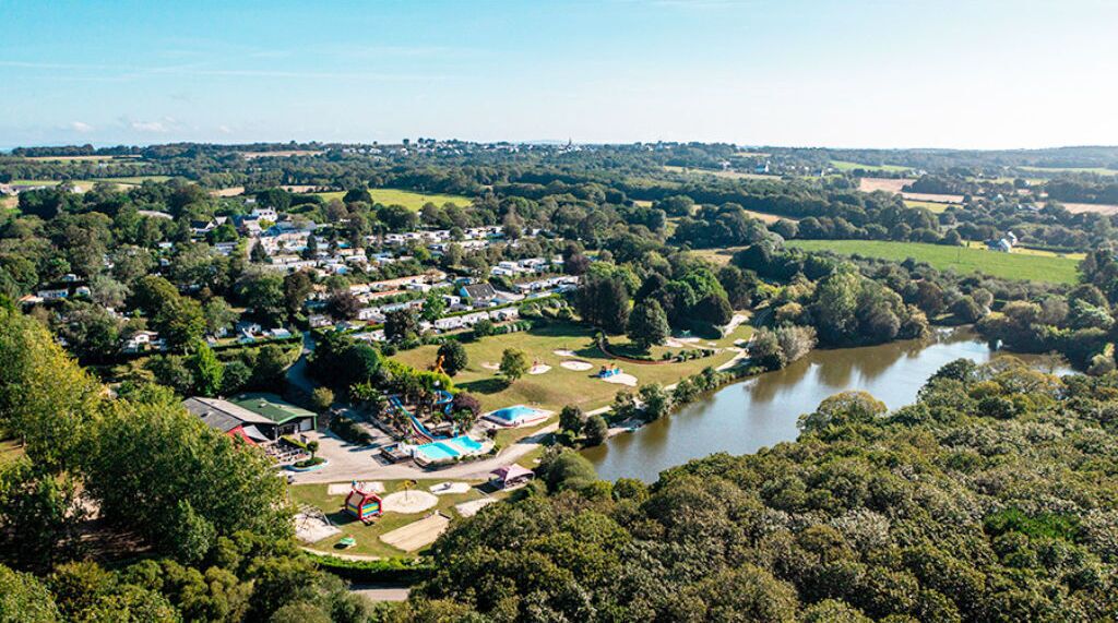 Luchtbeeld van een resort met meerdere gebouwen, een zwembad en een rivier.