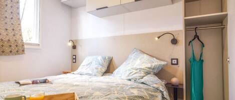 Une chambre à coucher avec un lit, une table de chevet, un plateau contenant des articles pour le petit-déjeuner et une armoire.