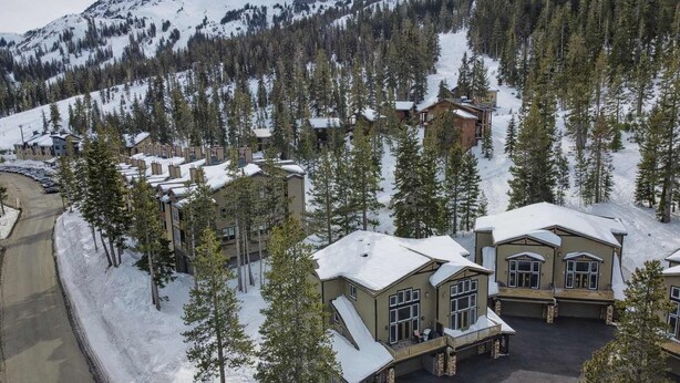 A snow-covered lodge with multiple buildings, surrounded by tall pine trees and a mountainous backdrop. - Kirkwood Mountainside Cabin w/Views, Walk to Lifts (Kirkwood)