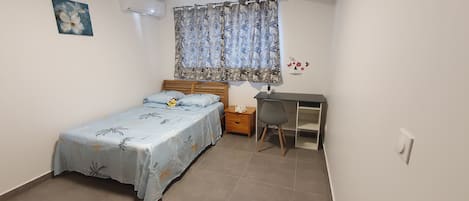 Une chambre à coucher avec un lit, un bureau et une chaise.