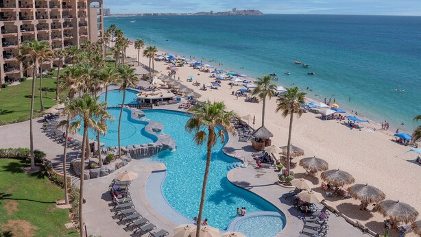 Ein Resort mit großem Pool, Strand und Meerblick.