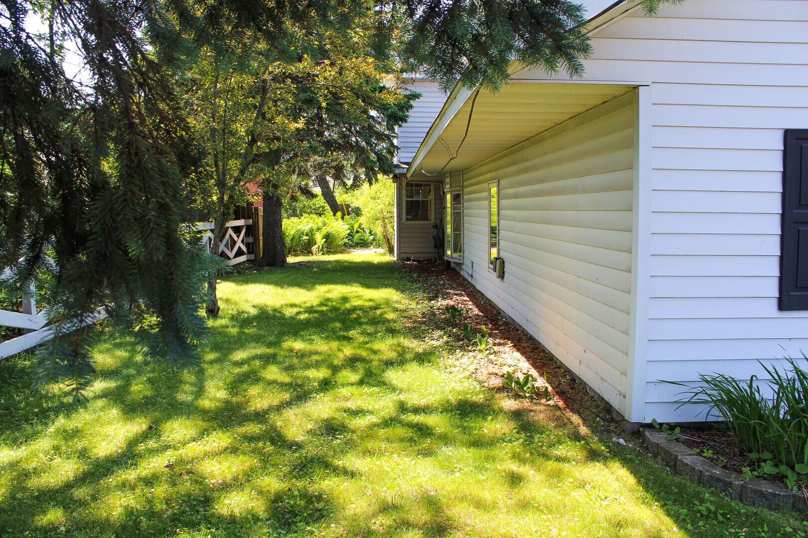 A house with a covered porch and a small garden area.