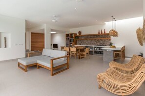 Relax in this open-plan living space with a sofa, lounge chair, and dining area.