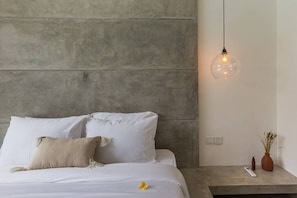 Experience a serene retreat with a bed, bedside table, and pendant light, creating a peaceful ambiance.
