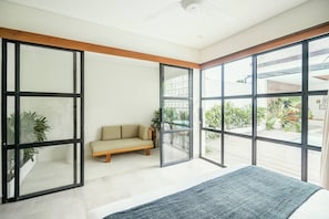 Relax in a spacious room with a sliding glass door leading to an outdoor area, featuring a sofa and rug.