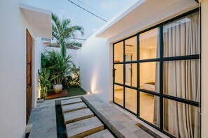Contemporary home with a clean exterior and lush garden, featuring a large sliding glass door.