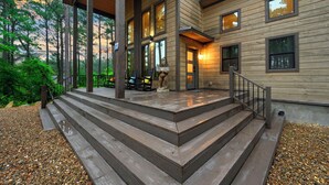 Una casa di legno con veranda, gradini e una statua.