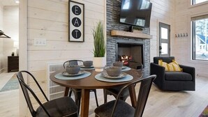 Una zona pranzo moderna con un tavolo rotondo, sedie e un caminetto.