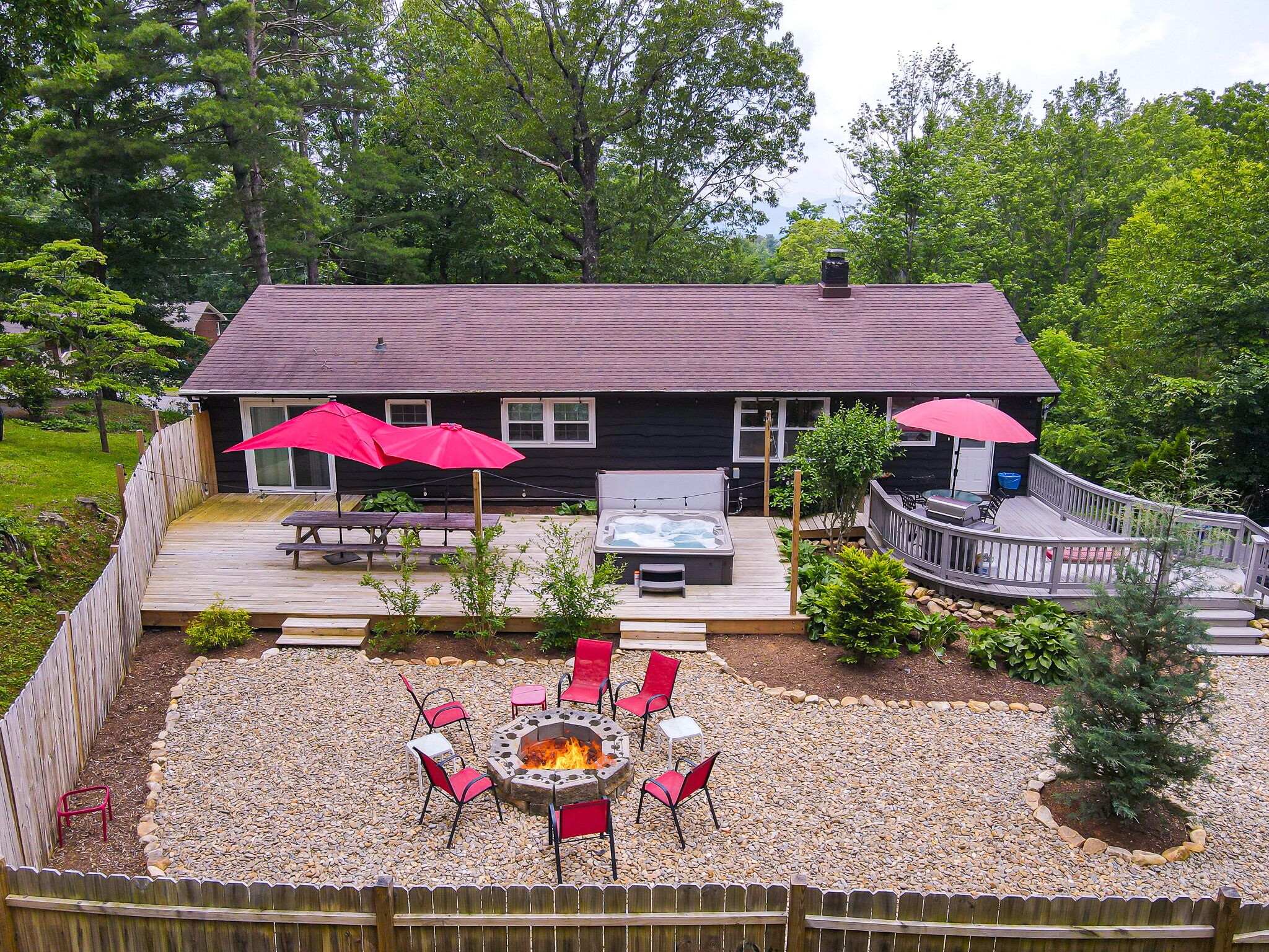 A house with a deck, outdoor seating, and a fire pit.