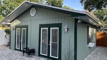 Stylish home with a green exterior, symmetrical doors, and a cozy porch.