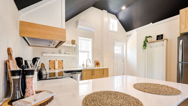 A modern kitchen with white cabinetry, a large island, and a black ceiling. - The Willow ⍋ | 1 Bed 1 Bath | 2nd Storey Suite (Kitchener)