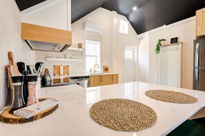 Eine moderne Küche mit weißen Schränken, einer großen Kochinsel und einer schwarzen Decke.